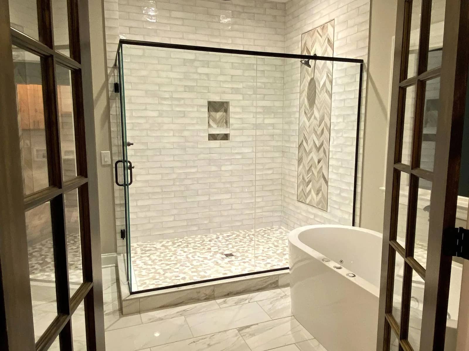Remodeled master bathroom with a tile shower and freestanding tub