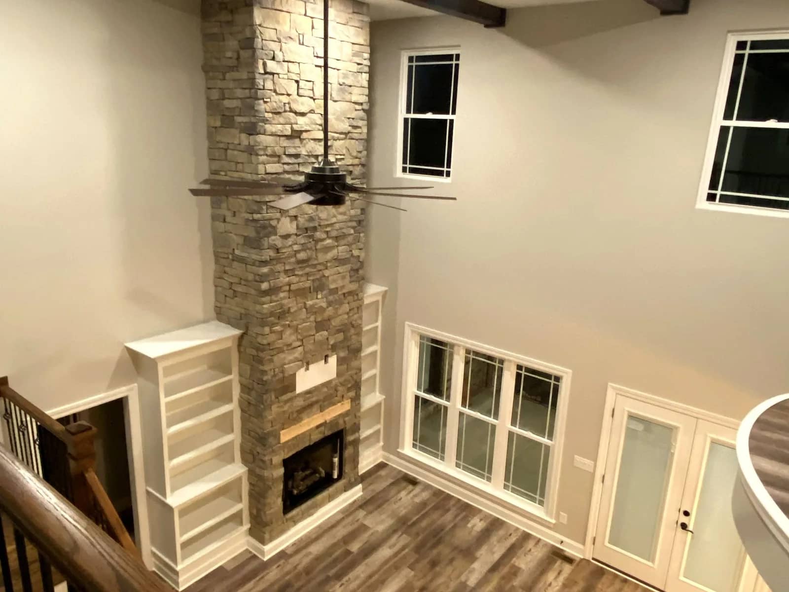 Great room with a stacked-stone fireplace in a custom home